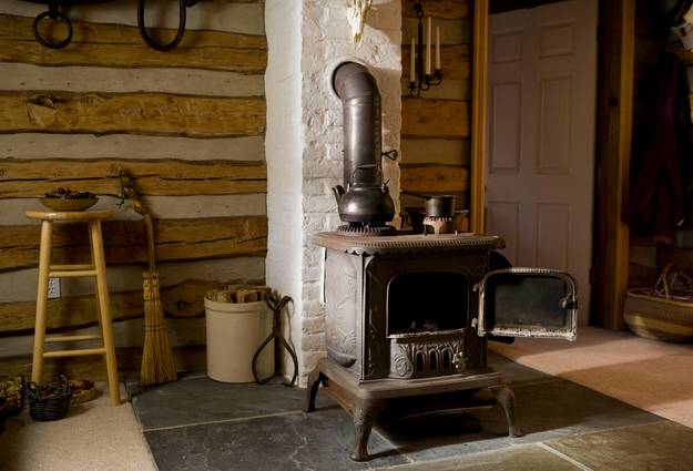 A classic cast iron coal stove operating in a cozy home or rustic cabin