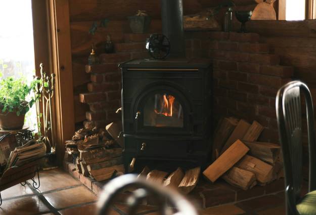 A classic wood stove burning brightly in a cozy living room or cabin