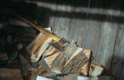 A professional using a rotary brush to clean a wood stove chimney and internal baffles