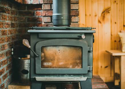 A homeowner installing or setting up an affordable heating stove in a budget-friendly home