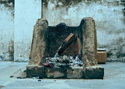 A homeowner unplugging and dusting the vents of an electric heating stove