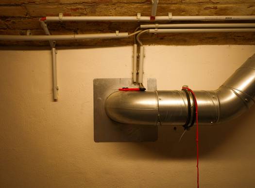 A professional installing a direct vent gas stove with sealed pipe