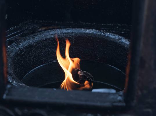 A professional installing a wood stove with proper venting and safety clearances