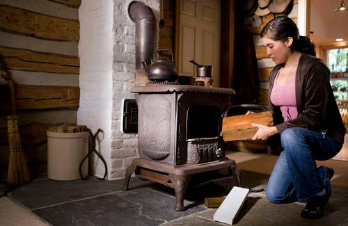 A person measuring a living room to determine the correct stove size