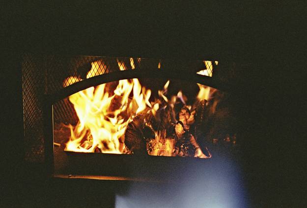 A modern pellet stove operating in a bright, comfortable living room