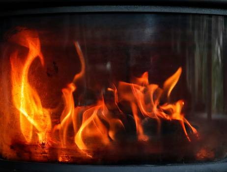 A close-up of a heating stove with visible certification and safety labels
