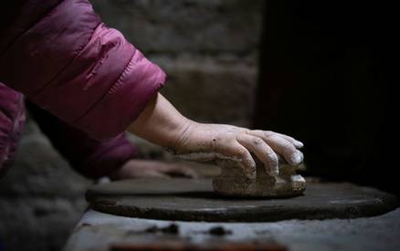 Close-up of hands cleaning stove glass with cloth and ash