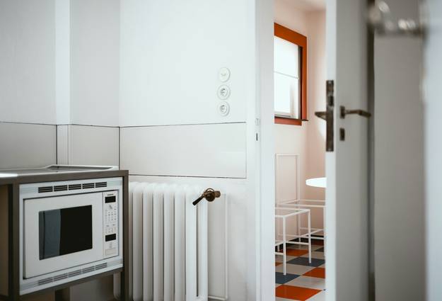 A professional installing a heating stove and venting system in a modern home