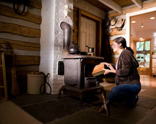 A person safely cleaning and maintaining their heating stove