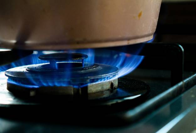 A homeowner or professional performing maintenance on a heating stove